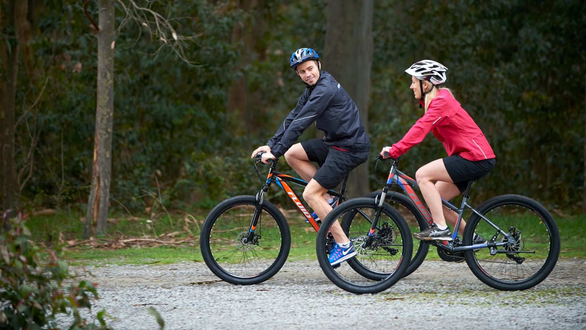 Man and woman riding Fluid Mountain Bikes on a trail