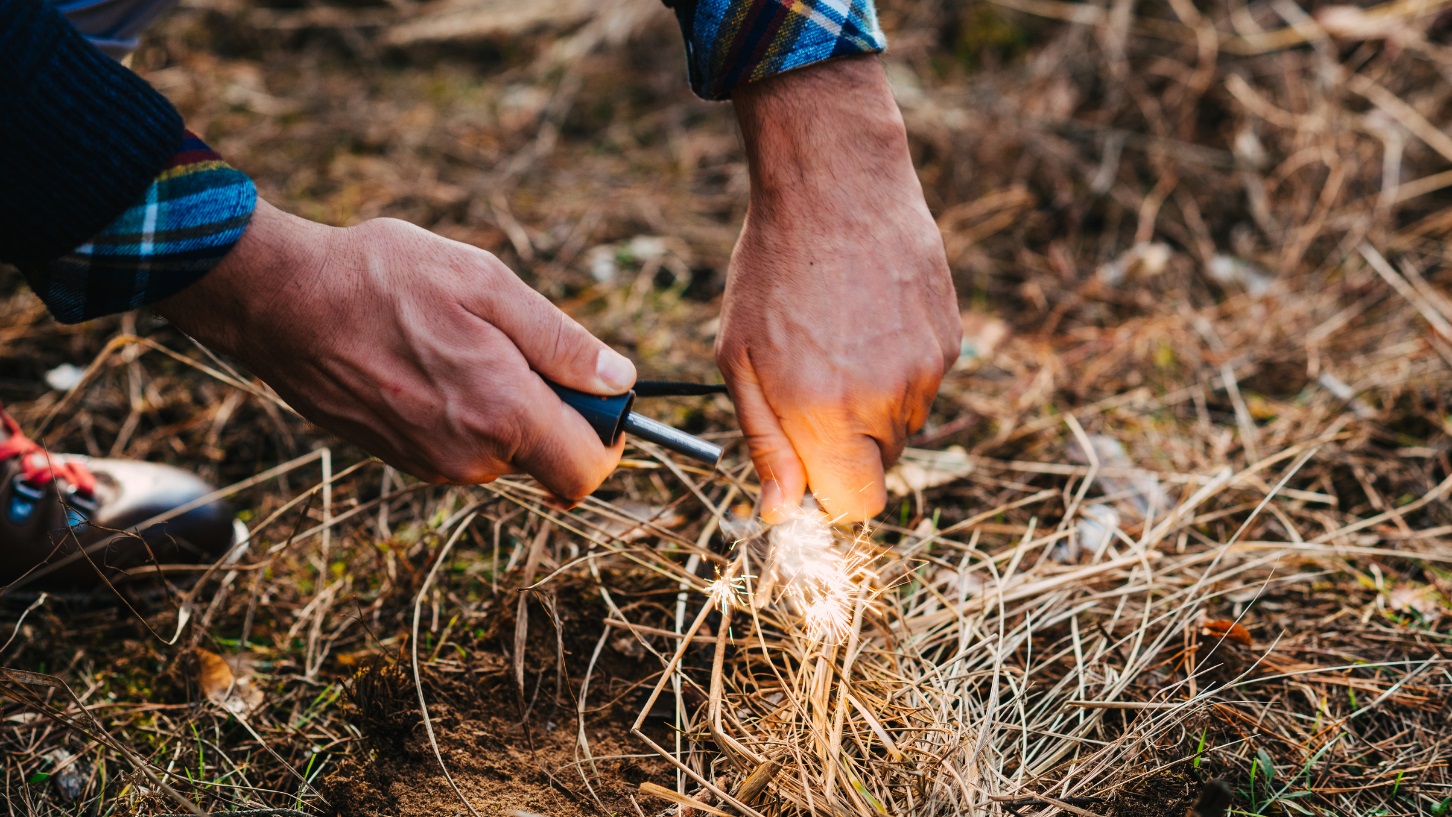 Hiker using Gerber Fire Starter on softwood kindling