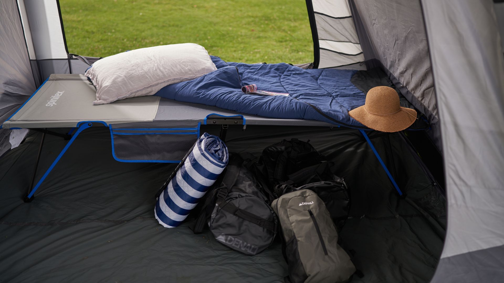 Camping tent set up with elevated bed and sleeping equipment